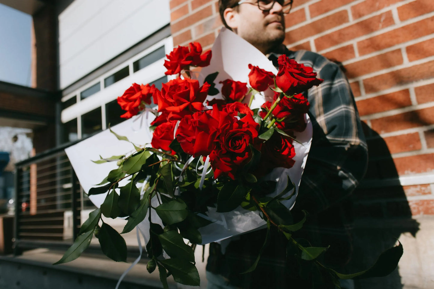 Close-up of two dozen red roses bouquet with textured greenery