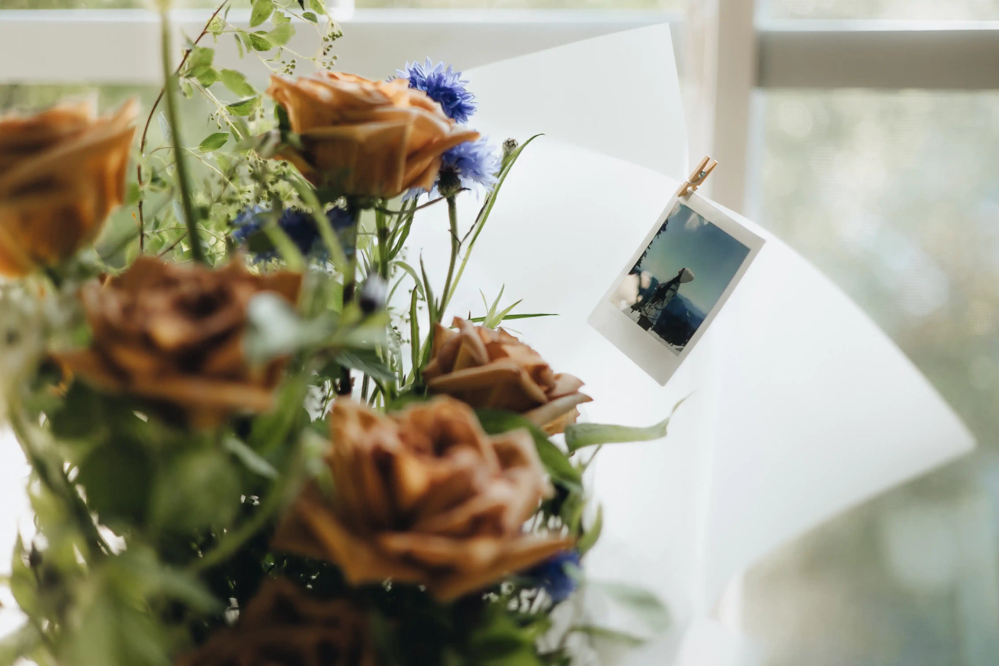 Fresh bouquet with golden roses, blue wildflowers, and a Polaroid photo — custom floral add-on by Kvetka Flower in Portland, OR.