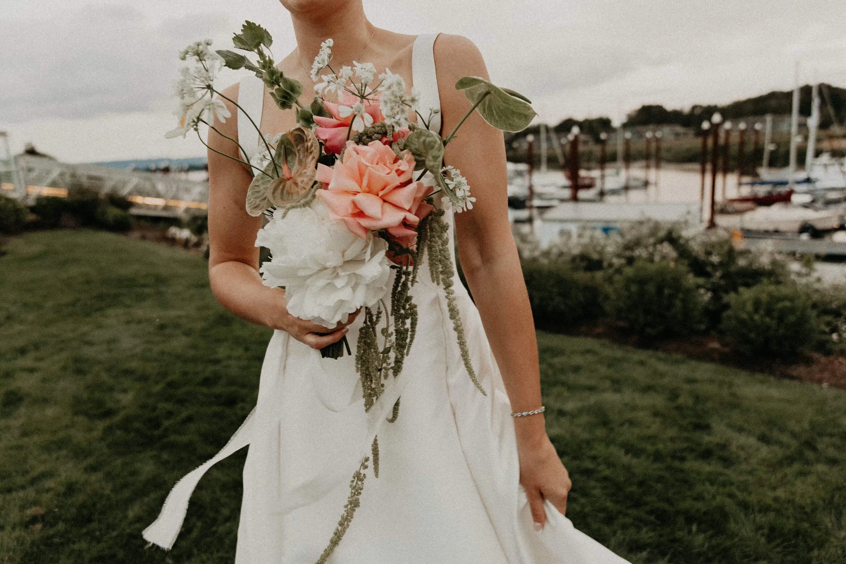 Bride in white dress holding modern wedding bouquet by Kvetka Flower — Portland waterfront ceremony
