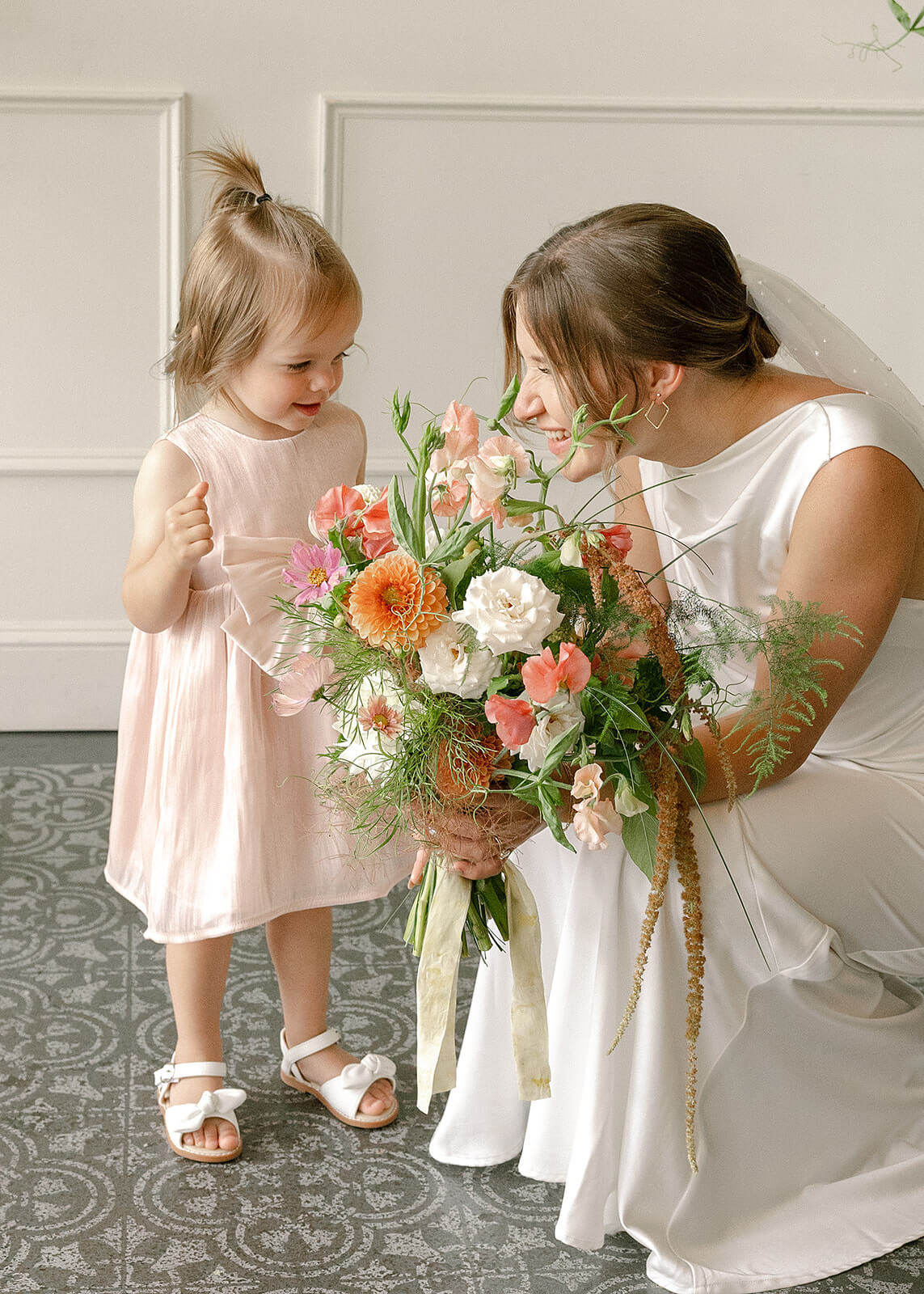 Bride smiling with a little girl while holding bridal bouquet at Tendue, Portland