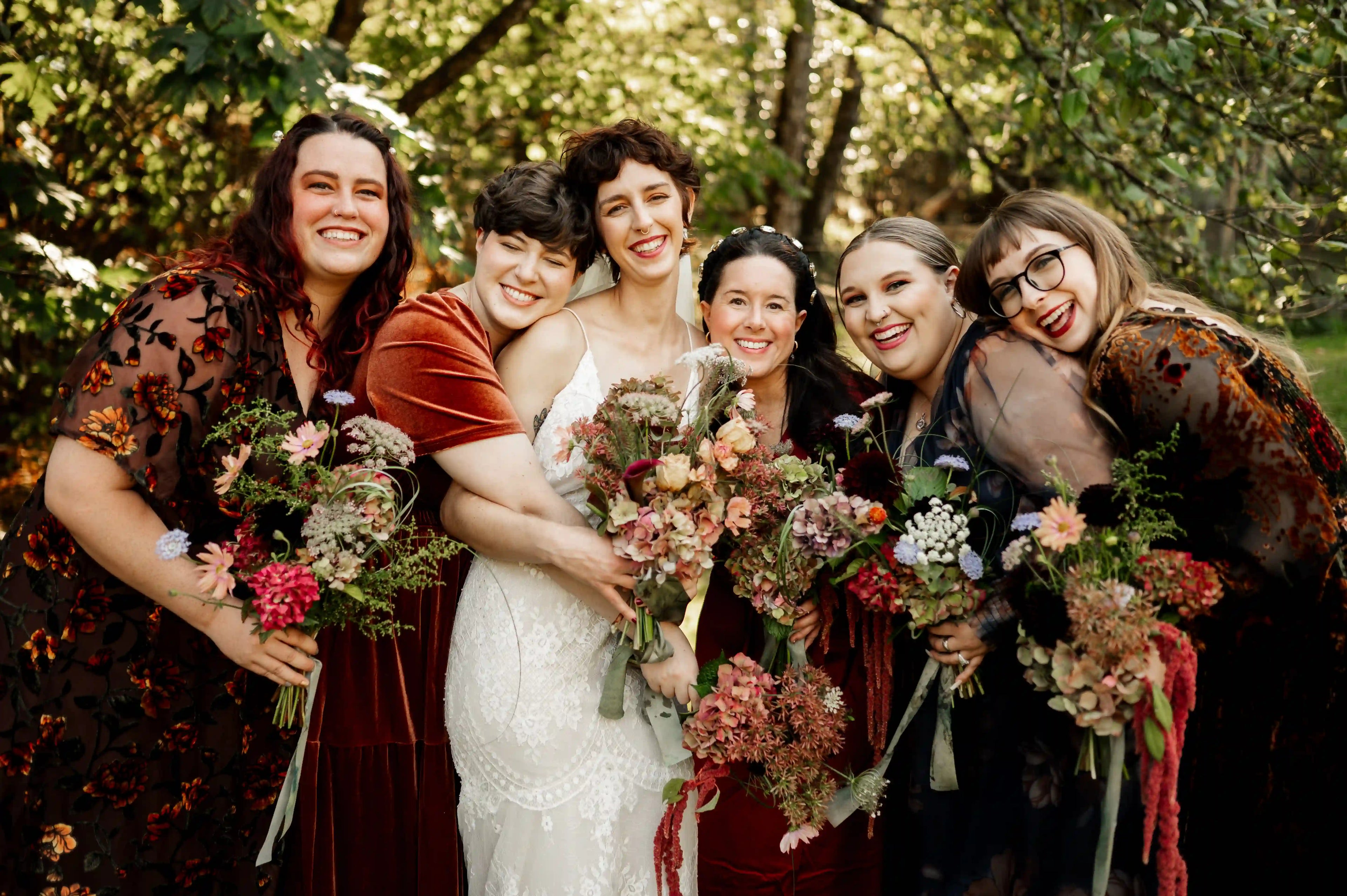 Bridesmaids holding rustic-style wedding bouquets with the bride — custom floral designs by Kvetka Flower in Portland