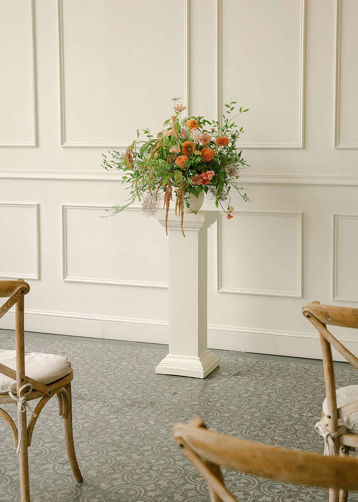 One floral ceremony arrangement with dahlias and greenery on a pedestal at Tendue
