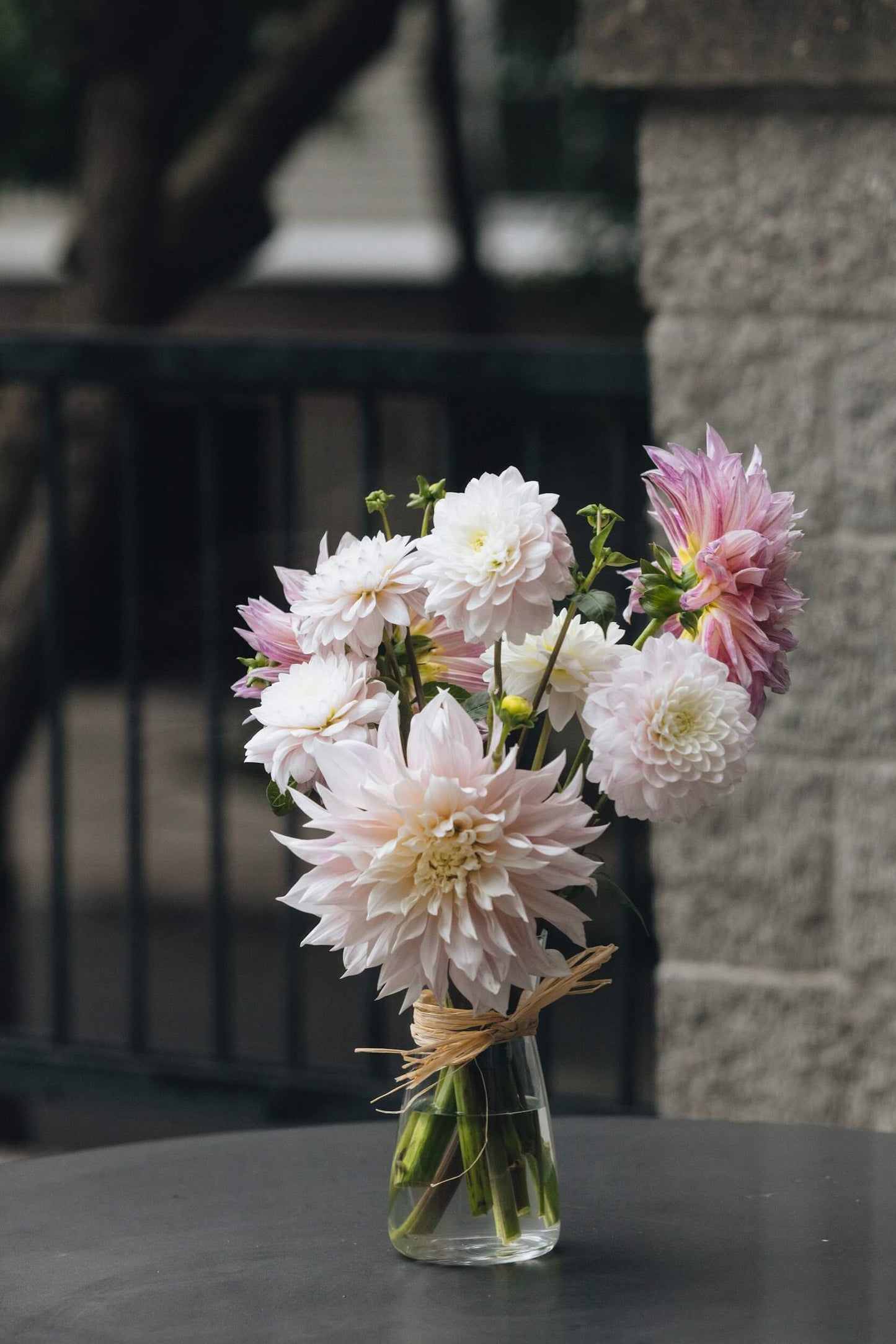 Soft pink dahlia bouquet with textured stone wall background, Kvetka Flower Portland