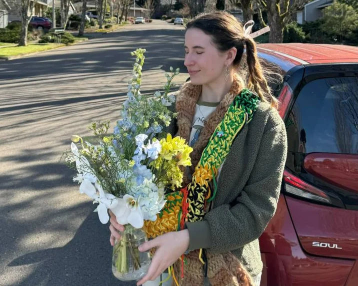 Young woman holding a vase with seasonal flowers — daily delivery in Portland by Kvetka Flower, from $10.