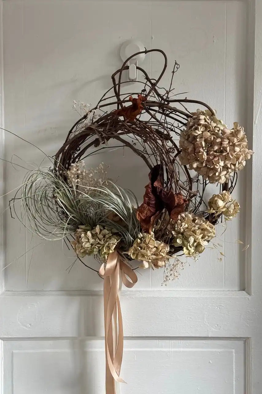Dried hydrangea wreath with grasses and silk ribbon on white front door by Kvetka Flower