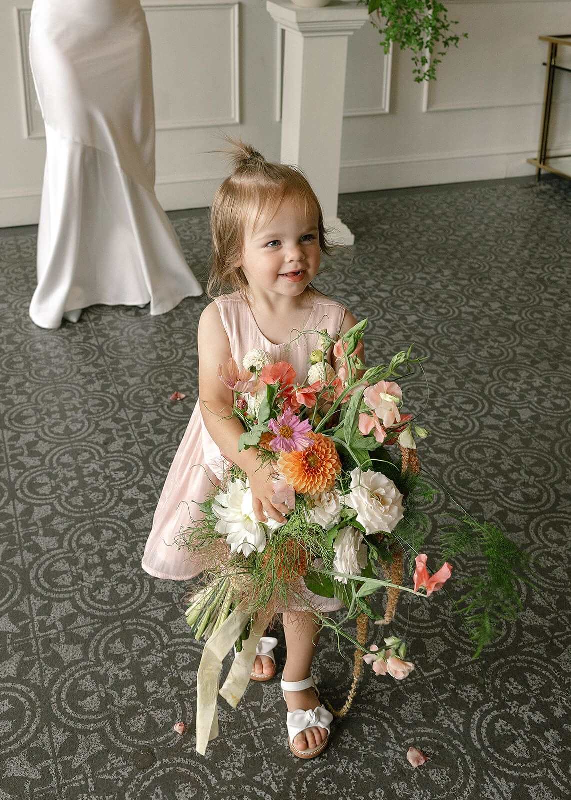 Flower girl holding a large garden-style bridal bouquet by Kvetka Flower