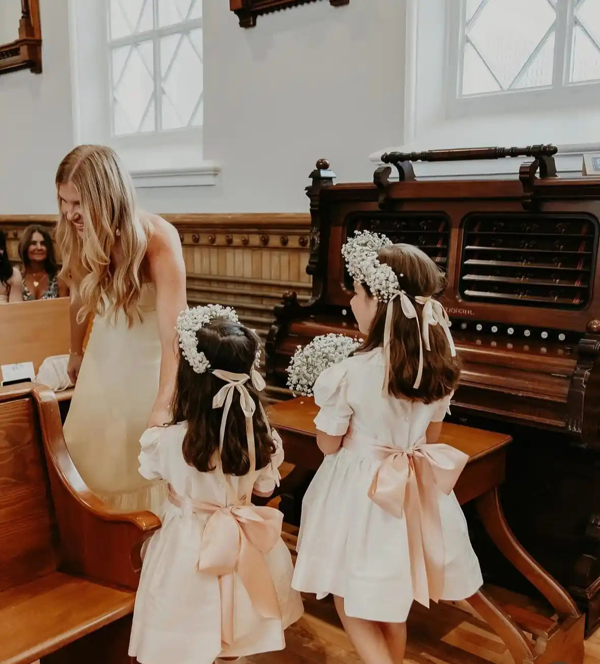 Flower girls wearing baby’s breath flower crowns and blush bows during a Portland wedding ceremony — florals by Kvetka Flower