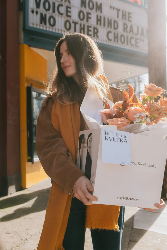 Woman holding I Love Beige bouquet with Kvetka Flower gift packaging