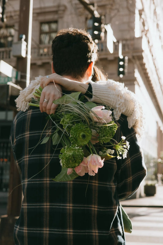 Couple embracing with wild green bouquet in Portland