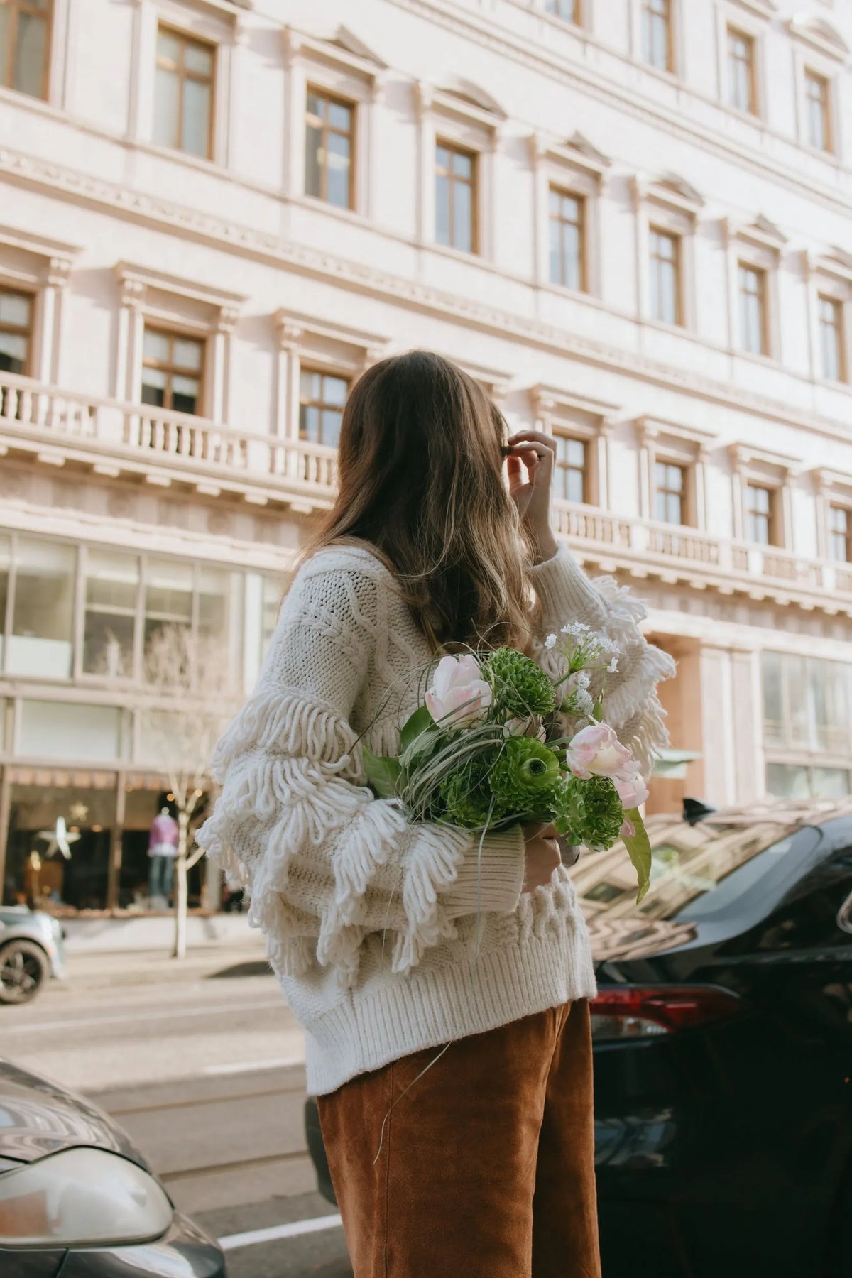 Woman carrying premium green bouquet downtown