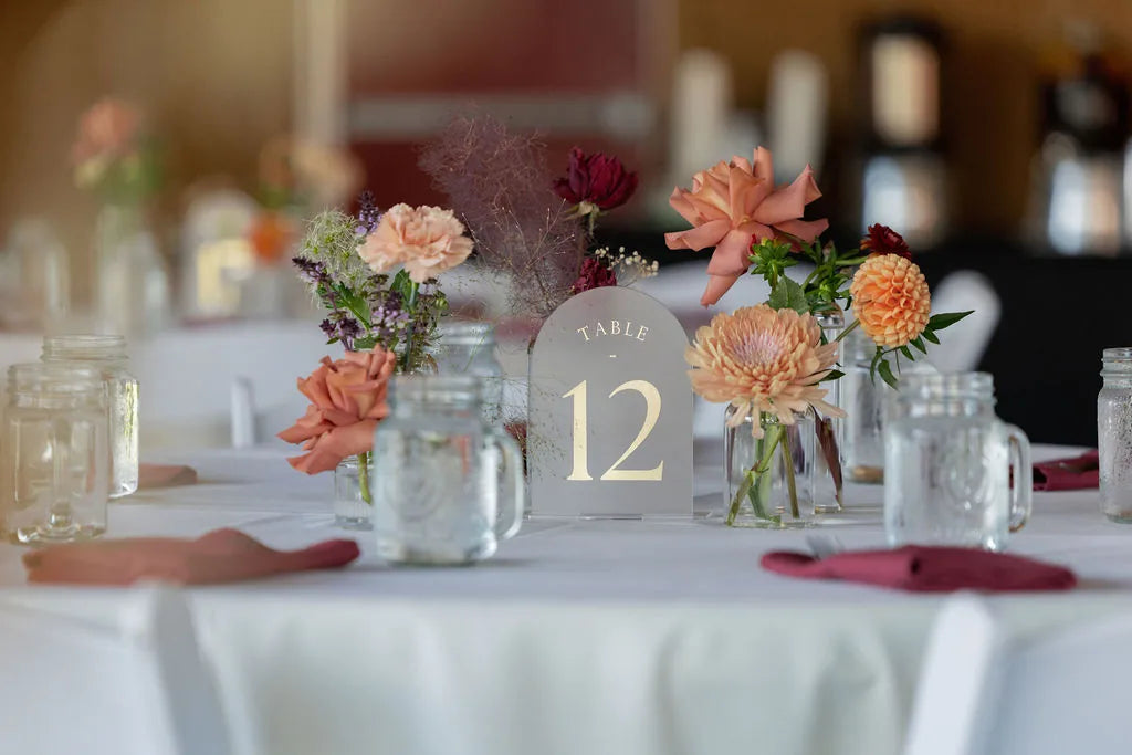 Bud vase wedding centerpieces with dahlias and roses for a rustic table setting.