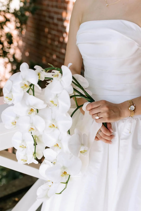 Close-up of cascading white orchid bridal bouquet with satin ribbon by Portland wedding florist Kvetka Flower