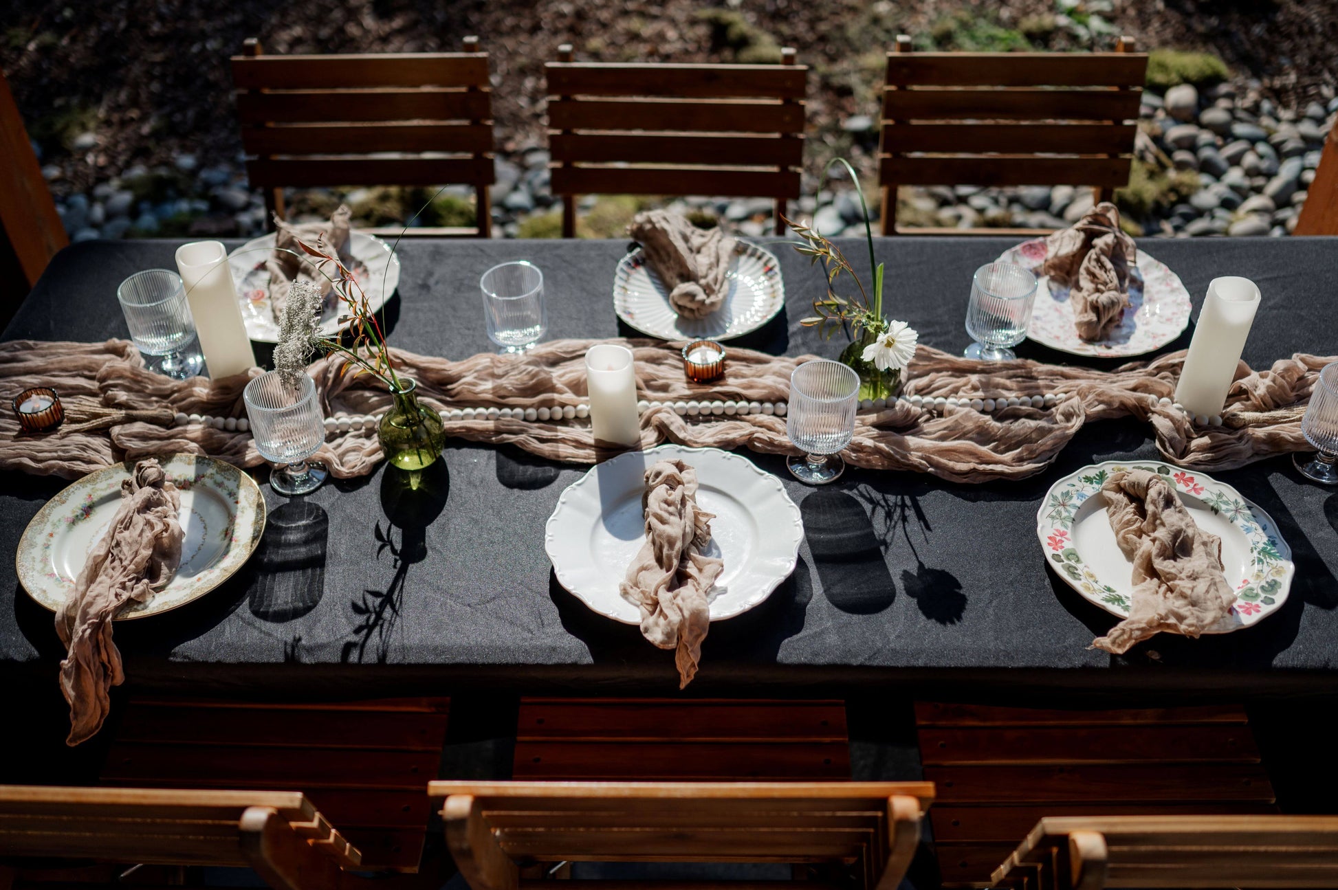 Cozy wedding tablescape with mismatched vintage plates, bud vases, black linen, and candlelight — Kvetka Flower Portland