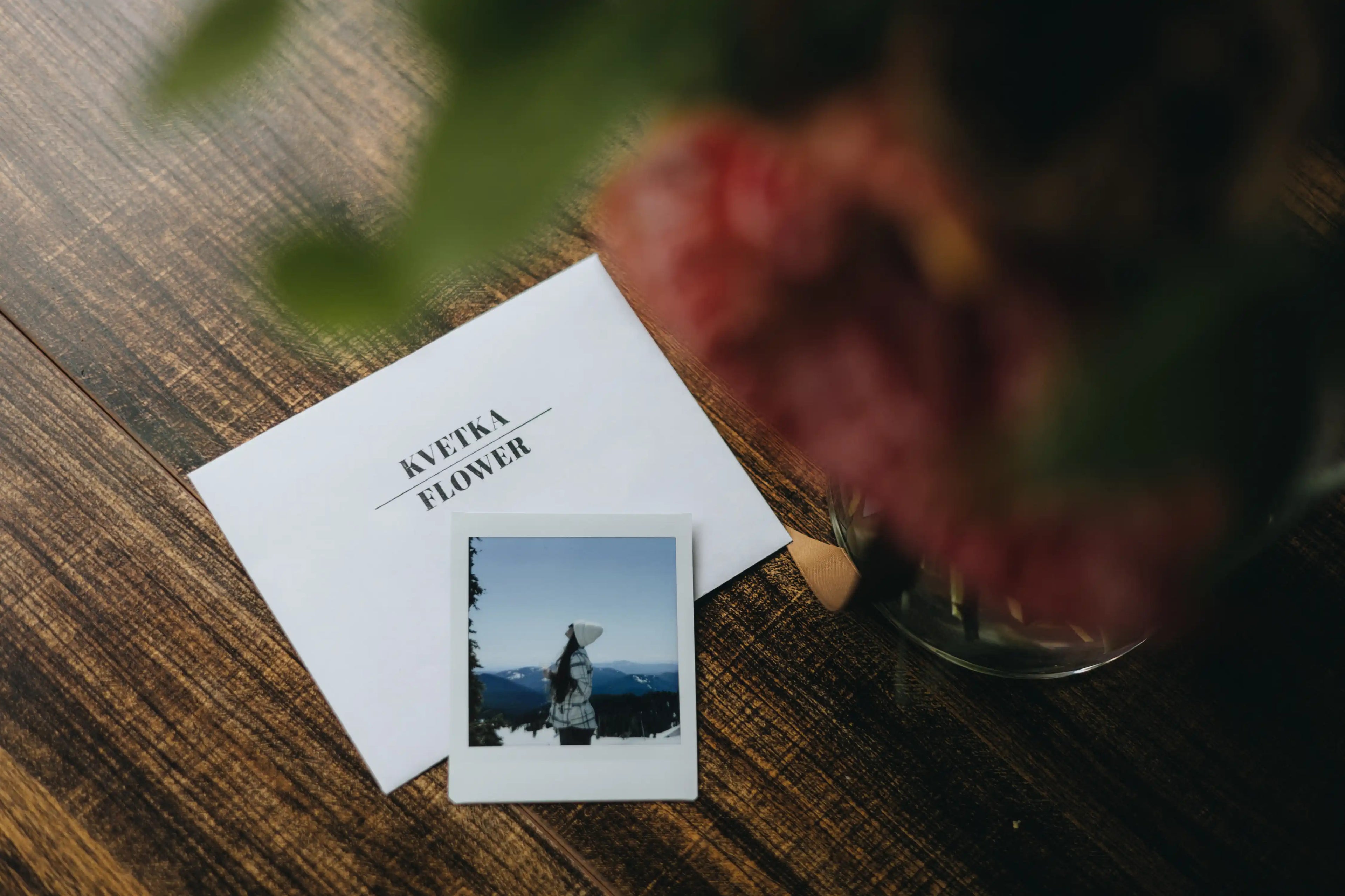 Polaroid photo on a table next to Kvetka Flower card and bouquet — a free add-on with flower delivery in Portland, OR.