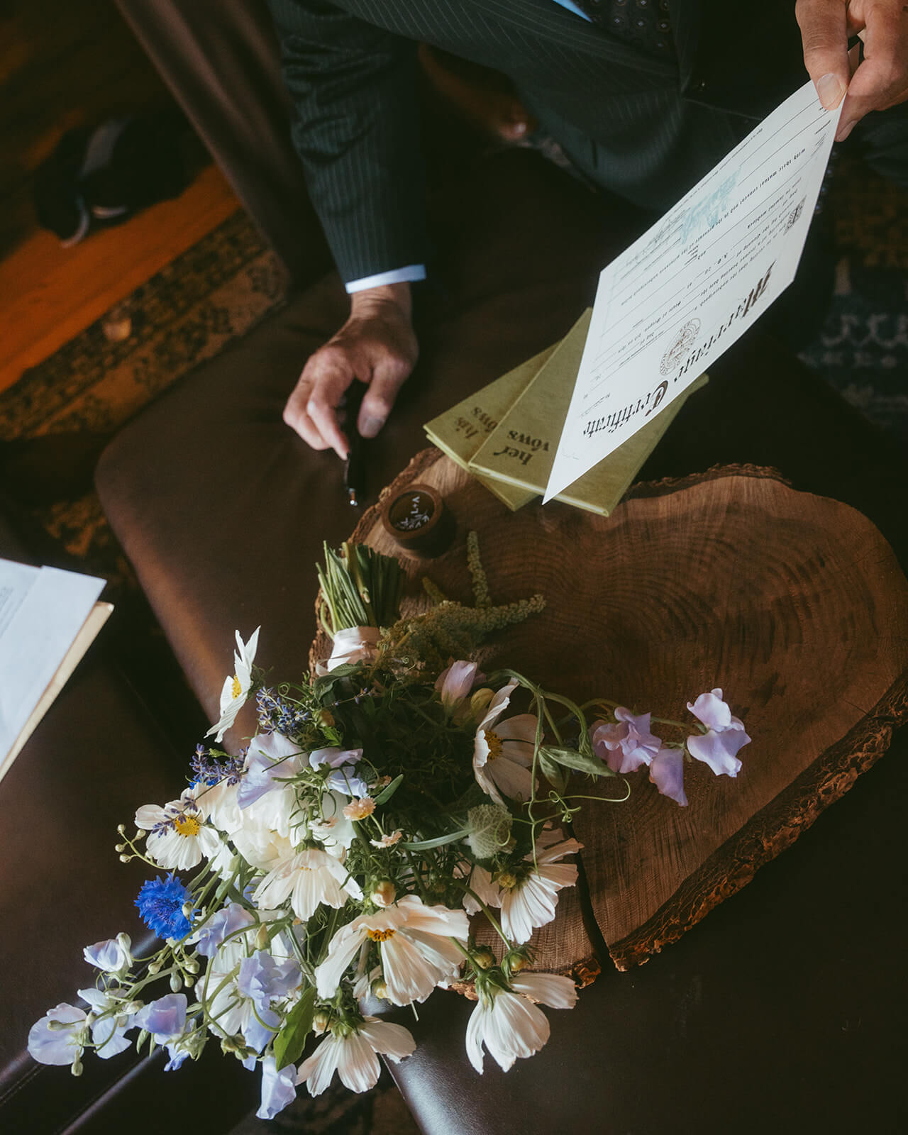 Groom signing wedding certificate next to bouquet of wildflowers by Kvetka Flower Portland OR