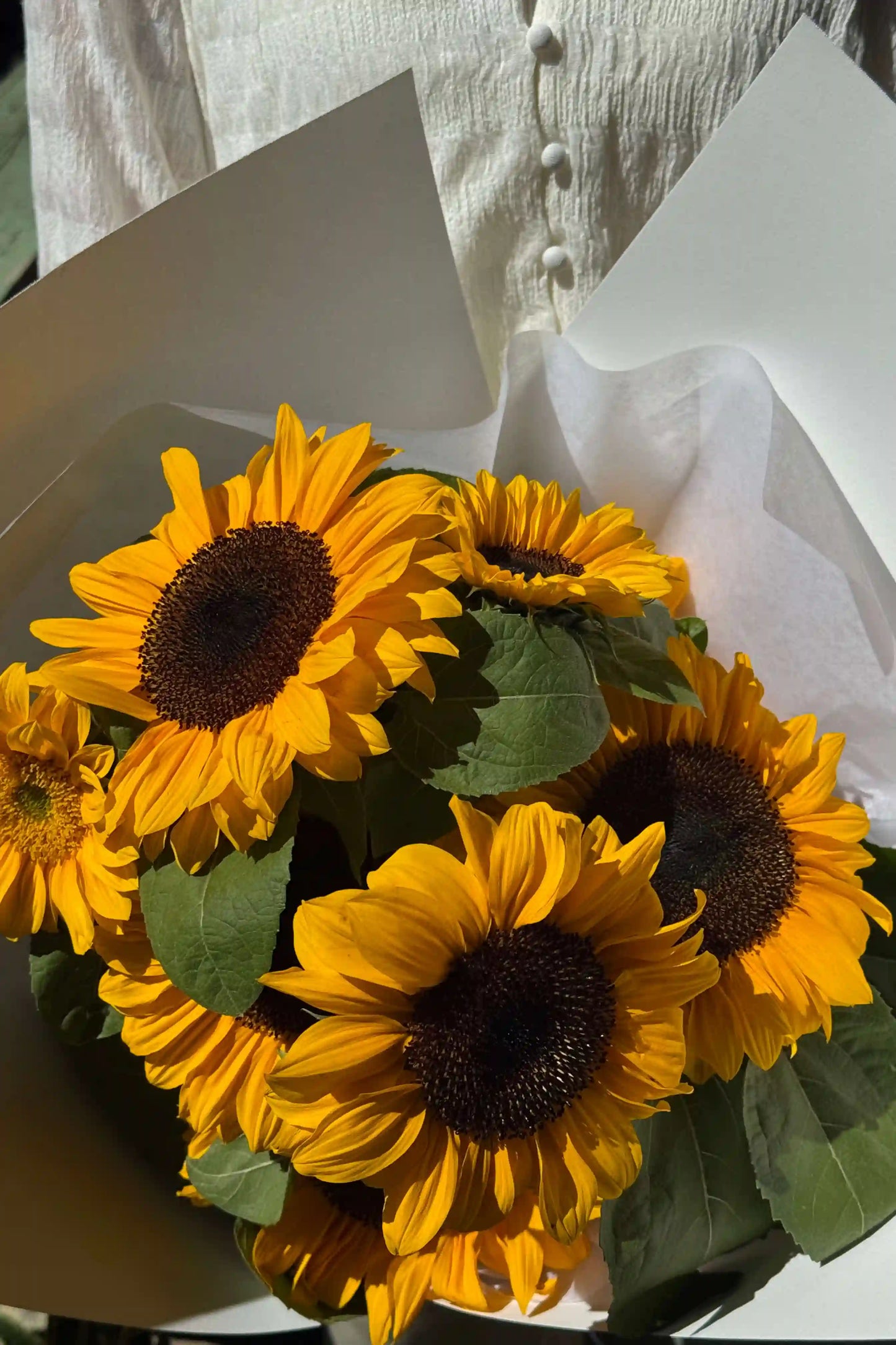 Sun Day sunflower bouquet resting on pavement with sunlight – small, bright, locally grown in Oregon, from Kvetka Flower