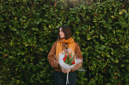 Woman holding a red tulip bouquet wrapped with Kvetka Flower ribbon in Portland Oregon