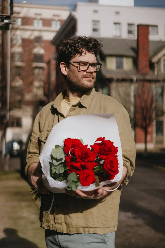 Man holding Valentine's Day red roses bouquet in downtown Portland