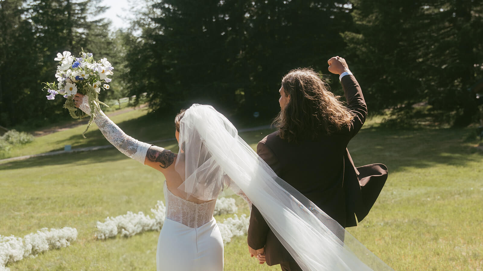 Bride and groom raising hands with bridal bouquet at mountain wedding by Kvetka Flower Portland OR