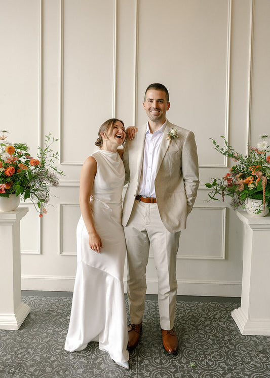 Bride and groom smiling in front of floral ceremony setup at Tendue Portland