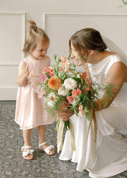 Bride smiling with a little girl while holding bridal bouquet at Tendue, Portland