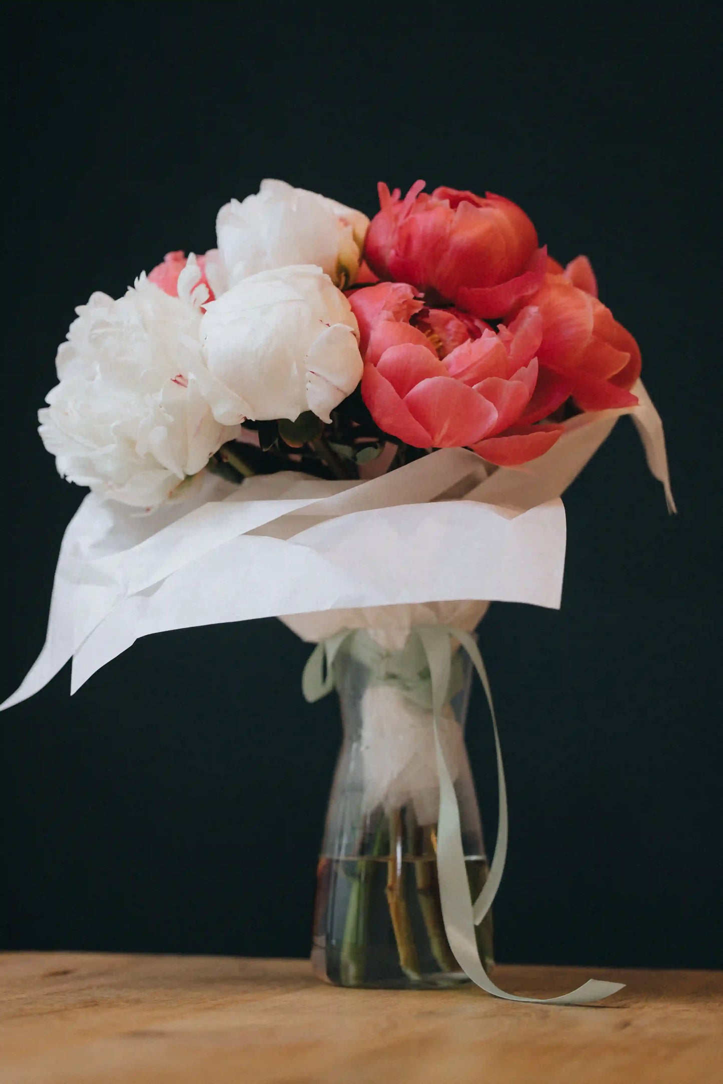 Wrapped bouquet of coral and white local peonies, summer flowers by Kvetka Flower in Portland