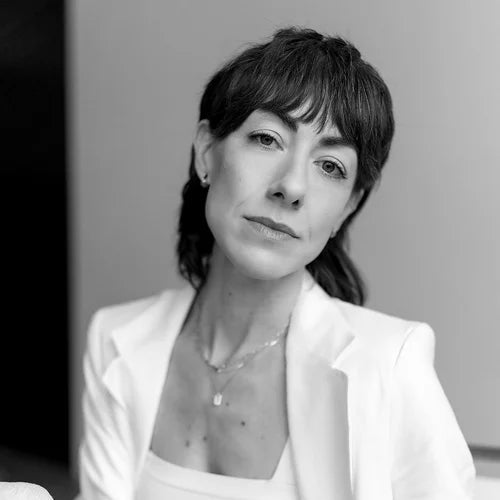 Black and white portrait of a woman wearing a white blazer.