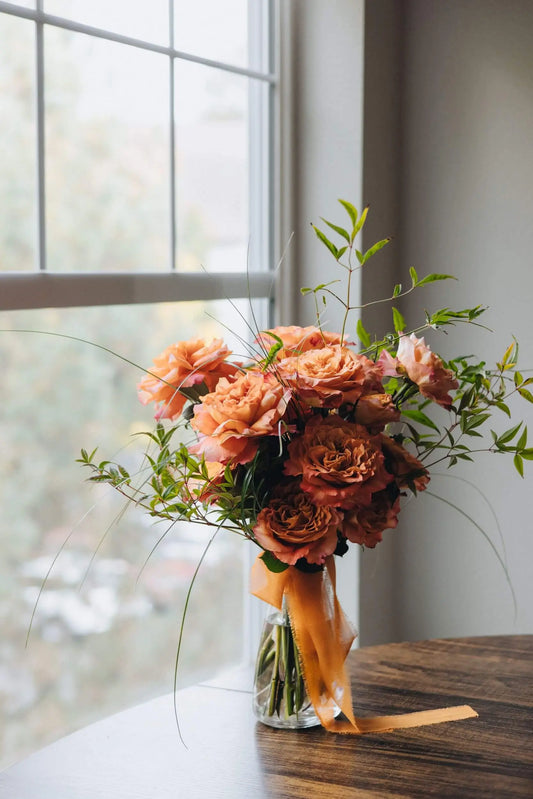 Classic orange rose bouquet in glass vase with greenery by Portland florist Kvetka Flower
