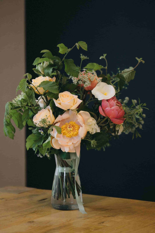 Detail of peach roses and foliage in a classic floral arrangement – Kvetka Flower
