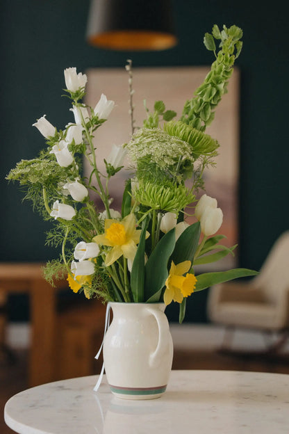 Custom flower bouquet medium with daffodils white tulips and bells of Ireland in ceramic vase by Kvetka Flower Portland Oregon