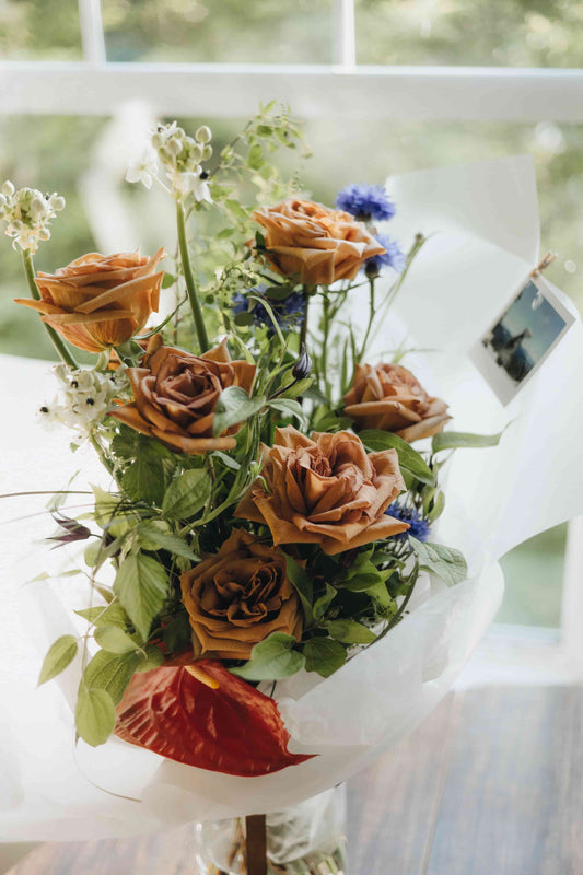 Warm-toned bouquet with greenery, roses, and soft wrapping — Evening Letter by Kvetka Flower