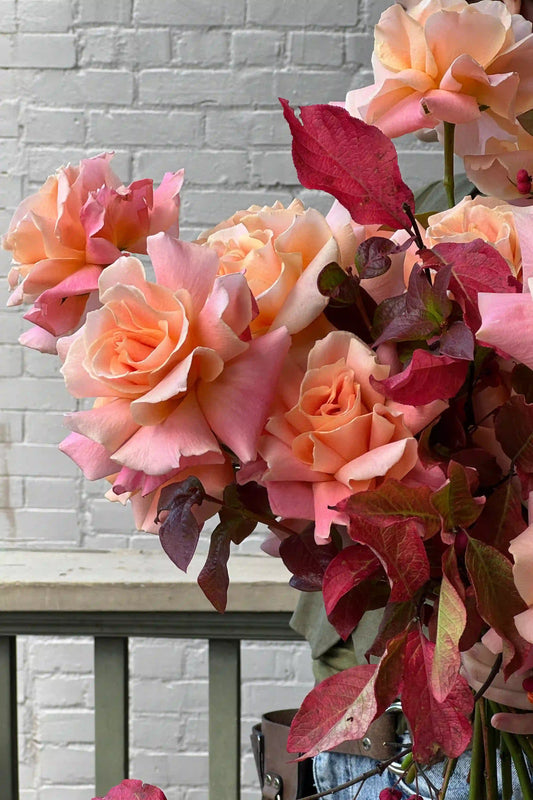 Fresh seasonal bouquet with peach roses and burgundy foliage by Kvetka Flower Portland florist for same-day delivery
