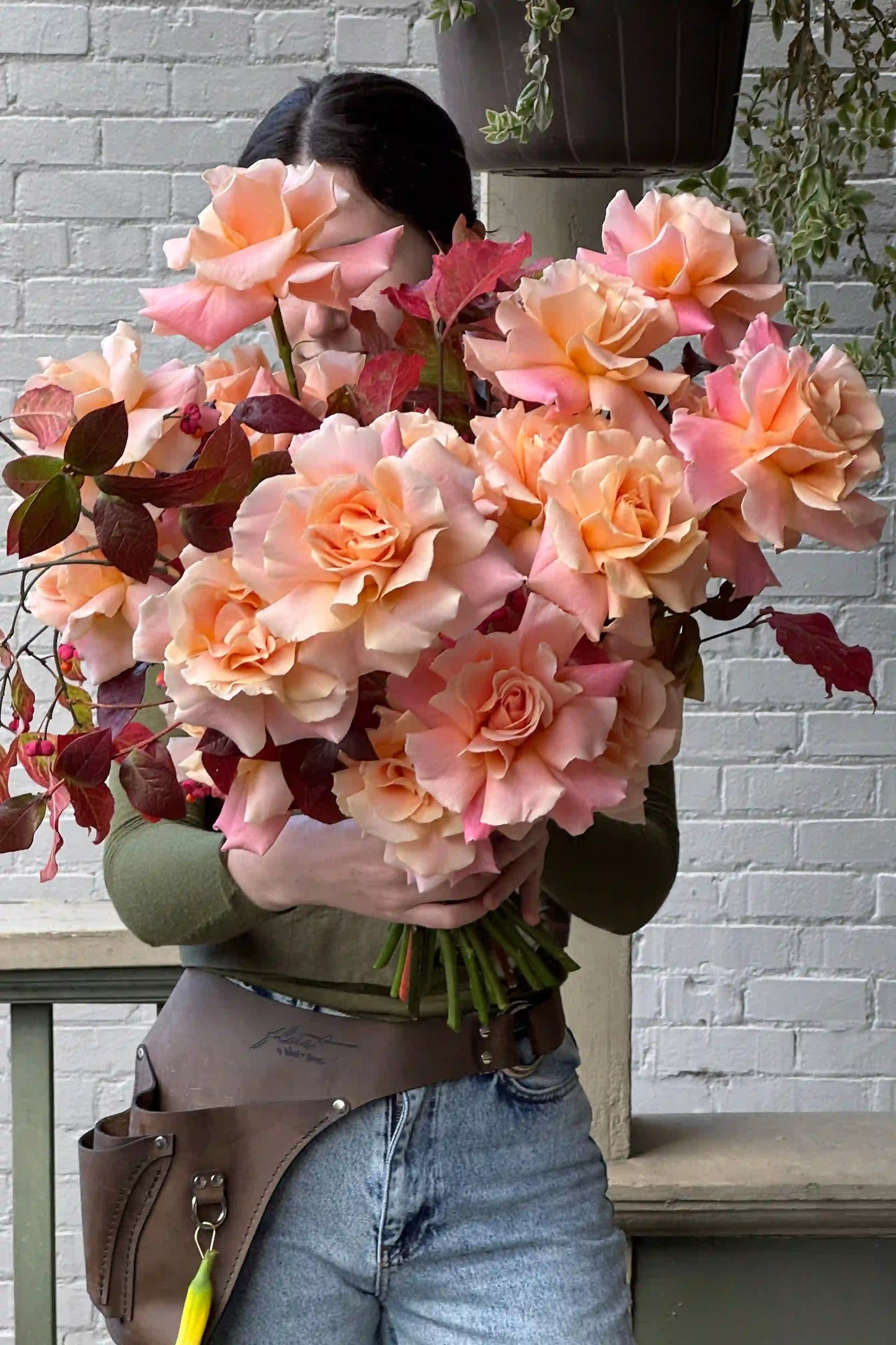 Hand-crafted seasonal rose bouquet in peach tones with burgundy accents by Portland Oregon florist Kvetka Flower for same-day delivery