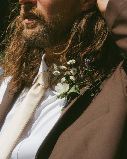 Close-up of groom wearing wildflower boutonniere by Kvetka Flower Portland OR