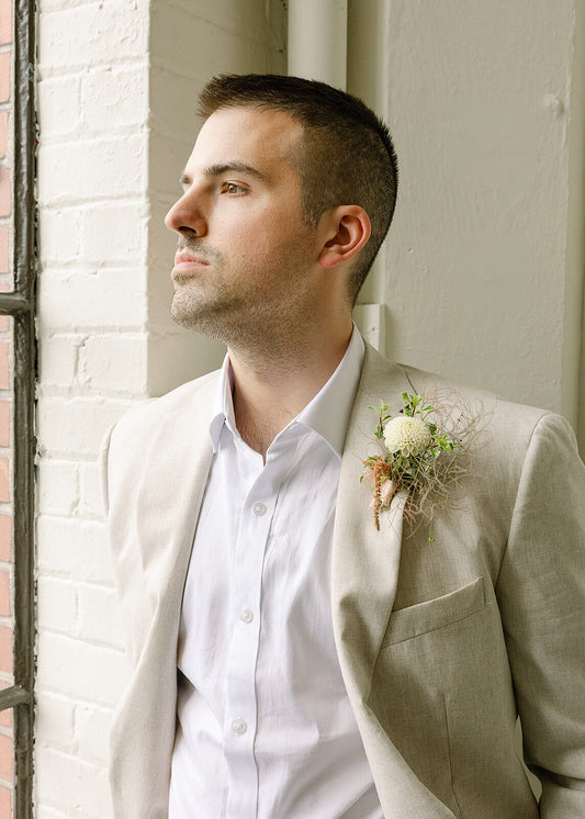 Groom looking out the window at Tendue with boutonniere by Kvetka Flower