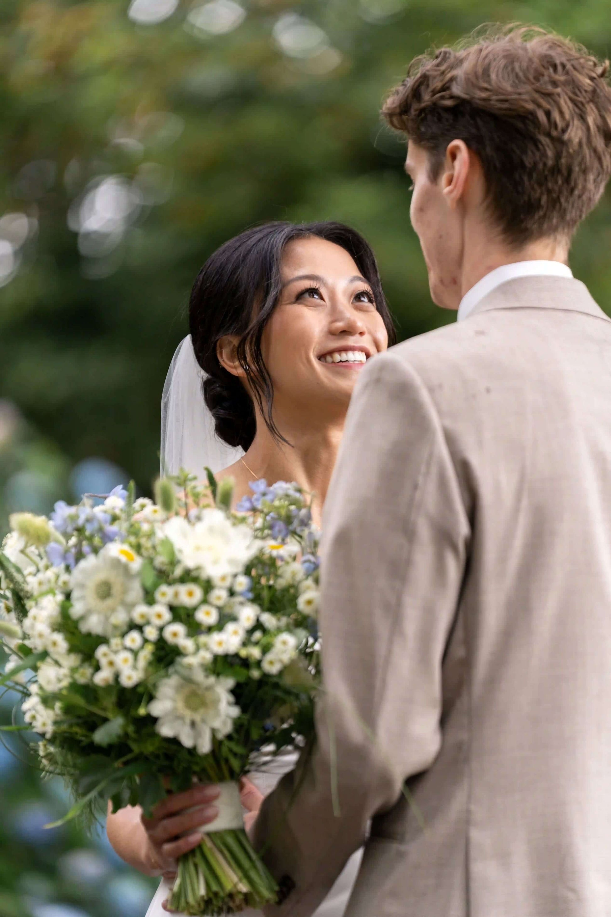 Bride looking up at groom, holding a fresh wedding bouquet by Kvetka Flower in Portland, OR