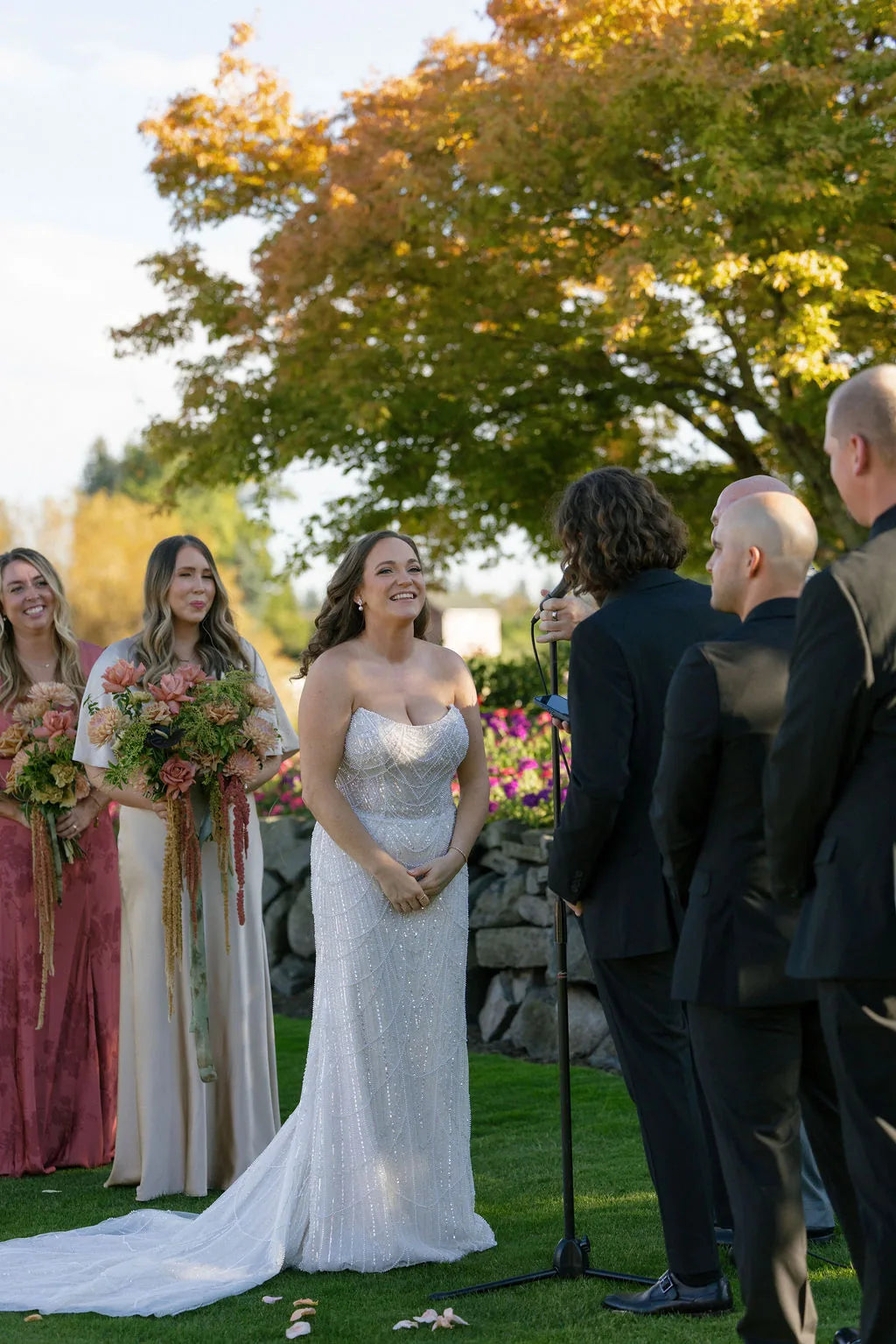 Radiant bride smiling during vows on the Red Shed Lawn at Langdon Farms.