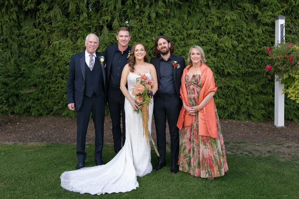 Family wedding portrait with rust wedding color scheme boutonnieres and bouquets.