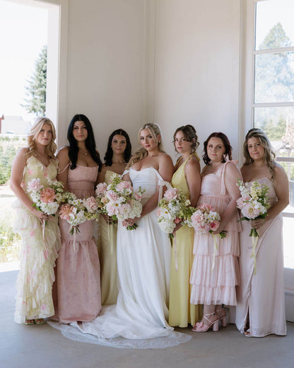 Bride and bridesmaids holding pastel-toned wedding bouquets by Kvetka Flower at a wedding in Portland.