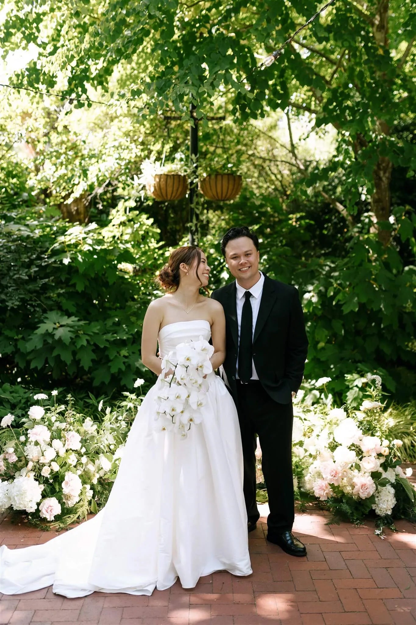 Bride and groom portrait at ceremony altar with lush ground floral installations by Kvetka Flower McMenamins Edgefield