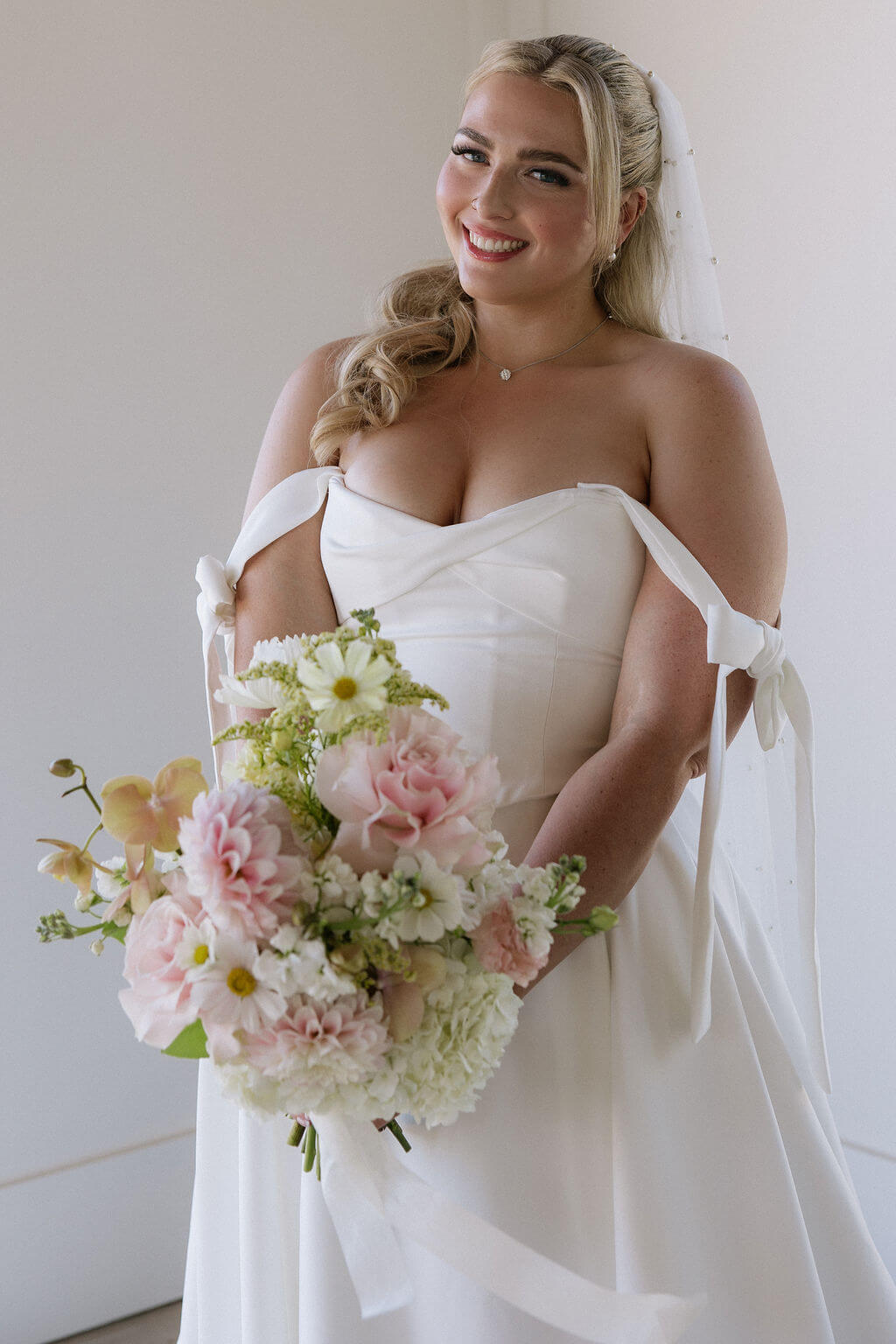 A bride holds her luxurious wedding bouquet by Kvetka Flower at a summer wedding at Redland Family Farm, Oregon.