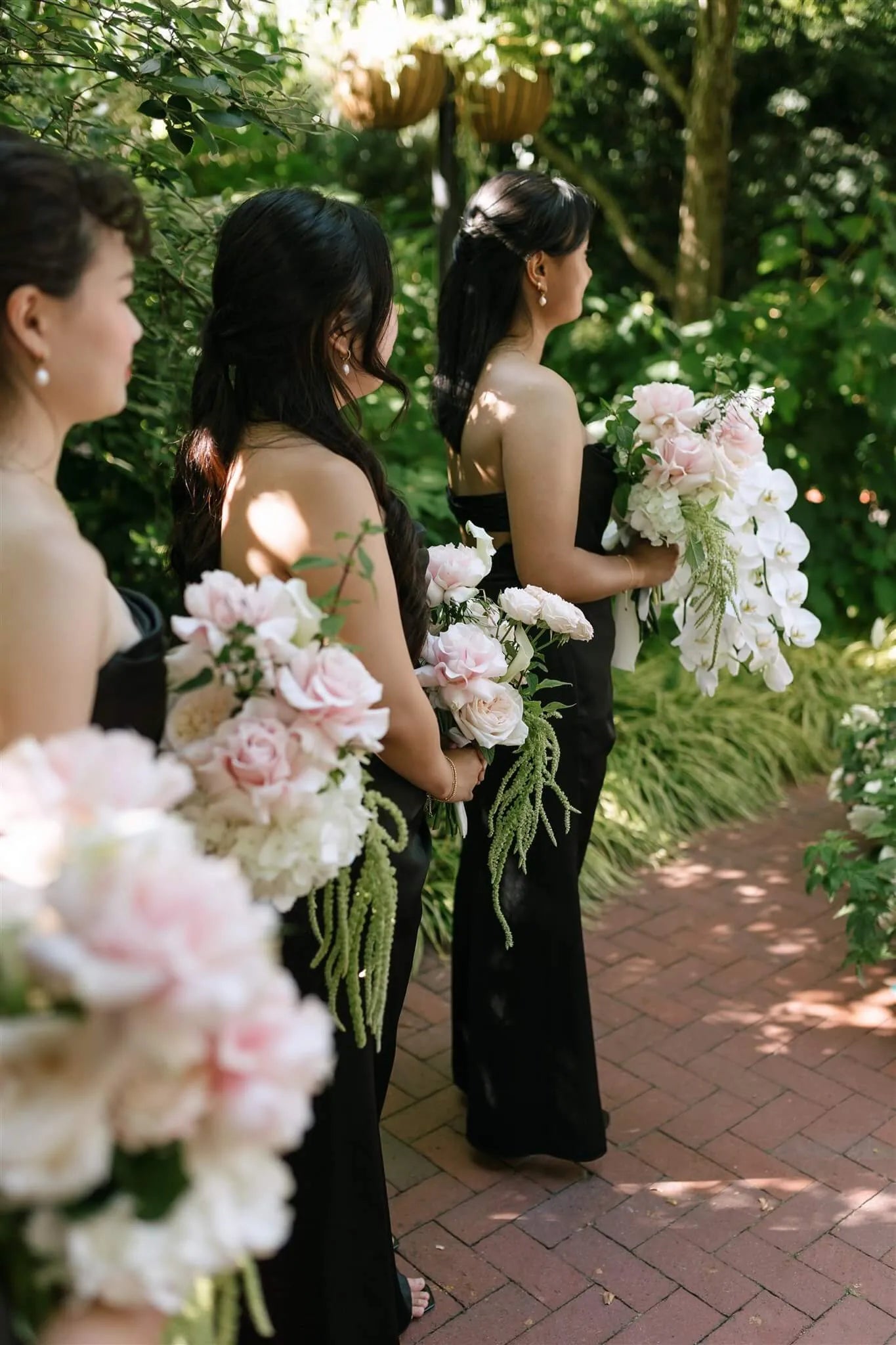 Bridesmaids in black dresses holding blush rose bouquets with trailing amaranthus during ceremony by Kvetka Flower Portland