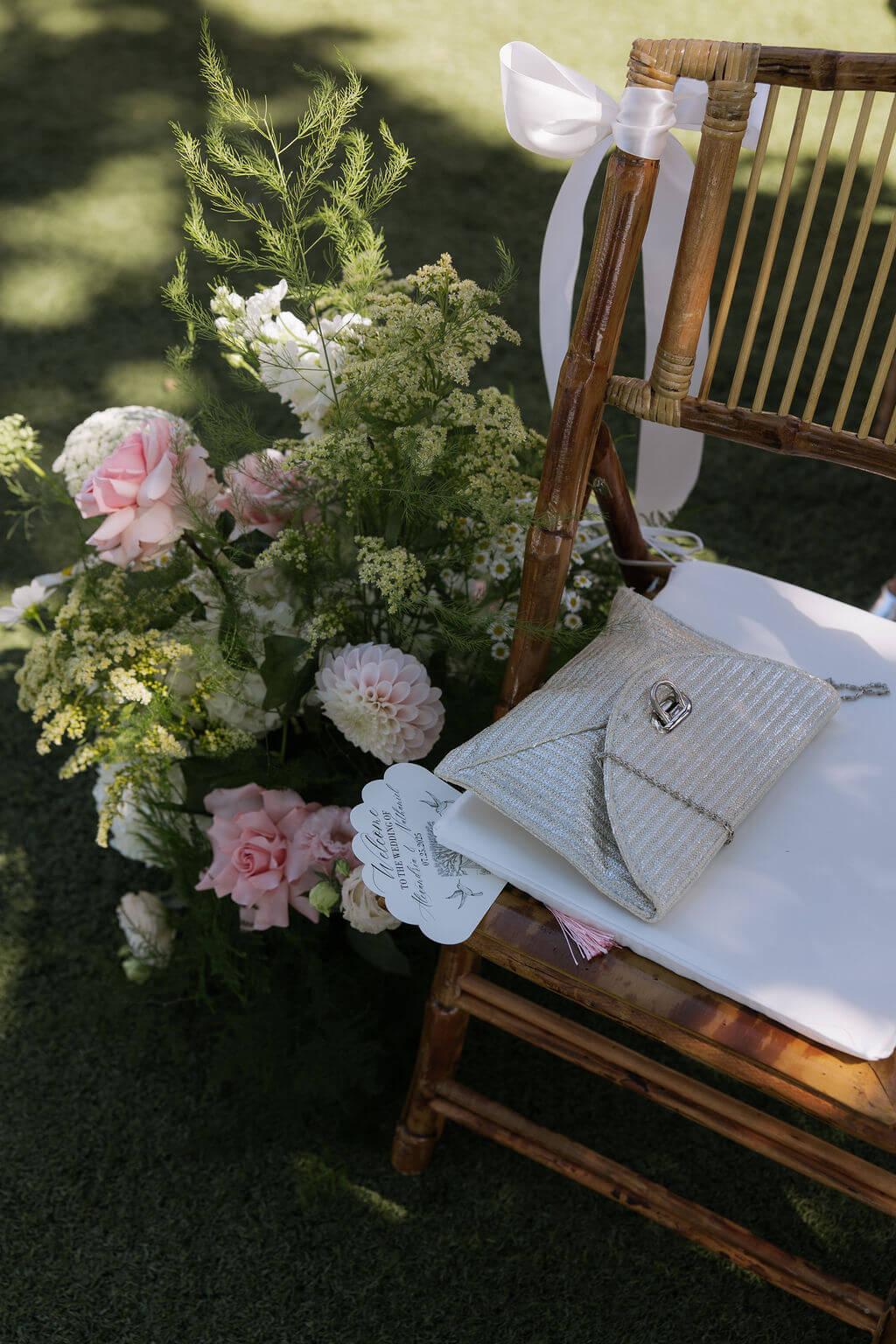 Close-up of floral decor for a chair at the Redland Family Farm wedding ceremony, featuring pink roses and dahlias.