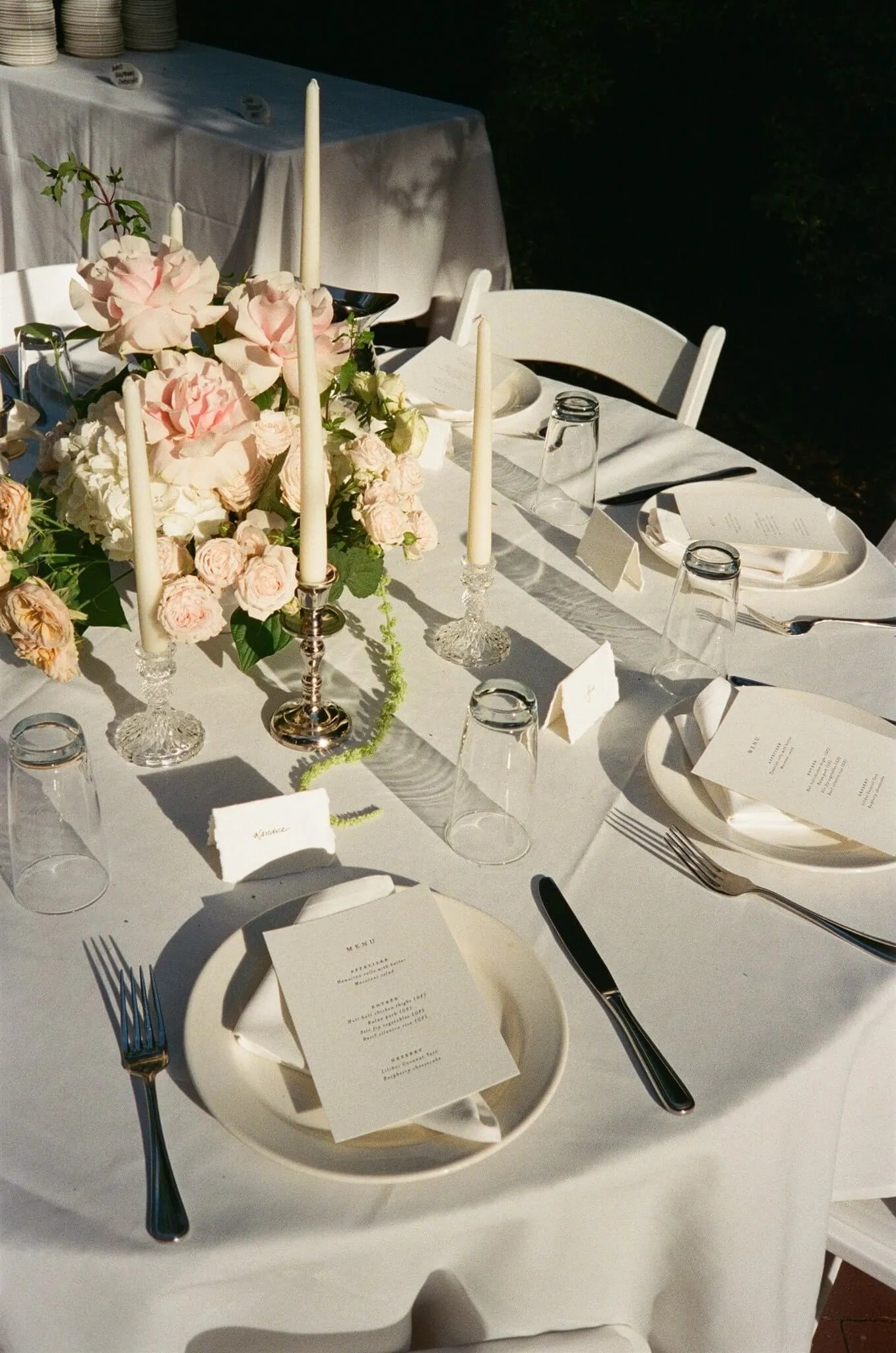 Round reception table with romantic rose centerpiece and taper candles by Portland wedding florist Kvetka Flower