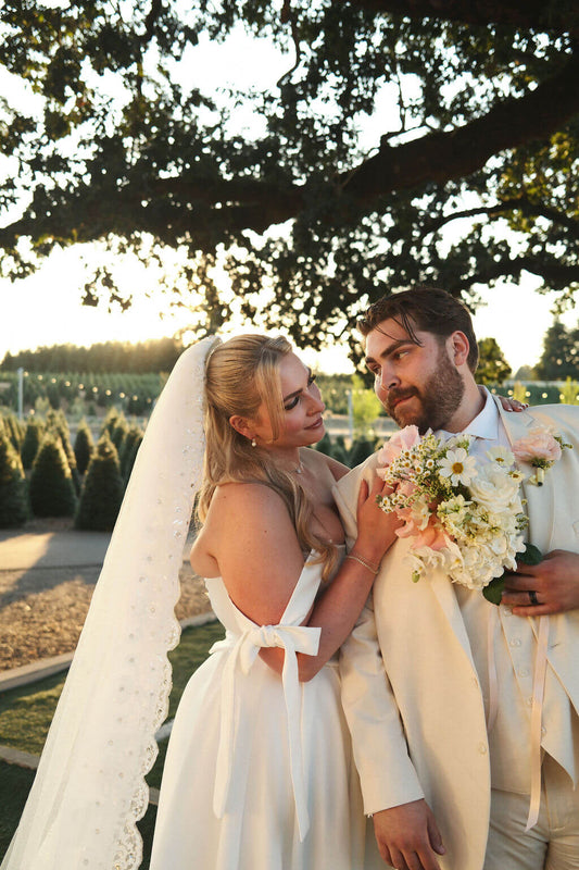 Bride and groom at their Redland Family Farm wedding; the bride holds a bouquet with roses and cosmos by Kvetka Flower.