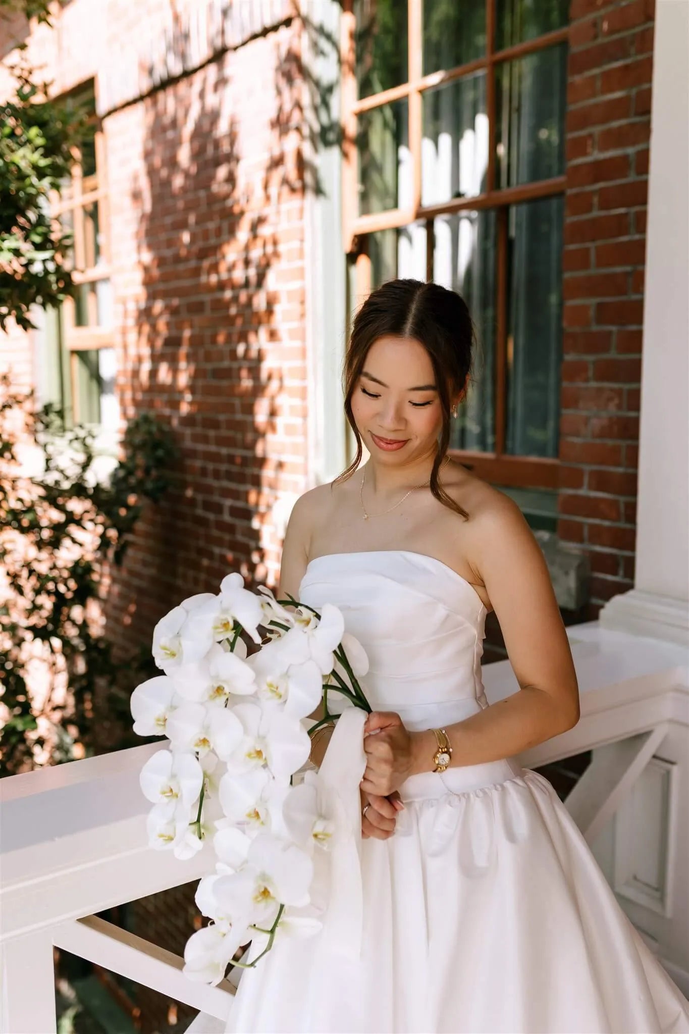 Bride holding cascading white phalaenopsis orchid bouquet by Kvetka Flower at McMenamins Edgefield Portland