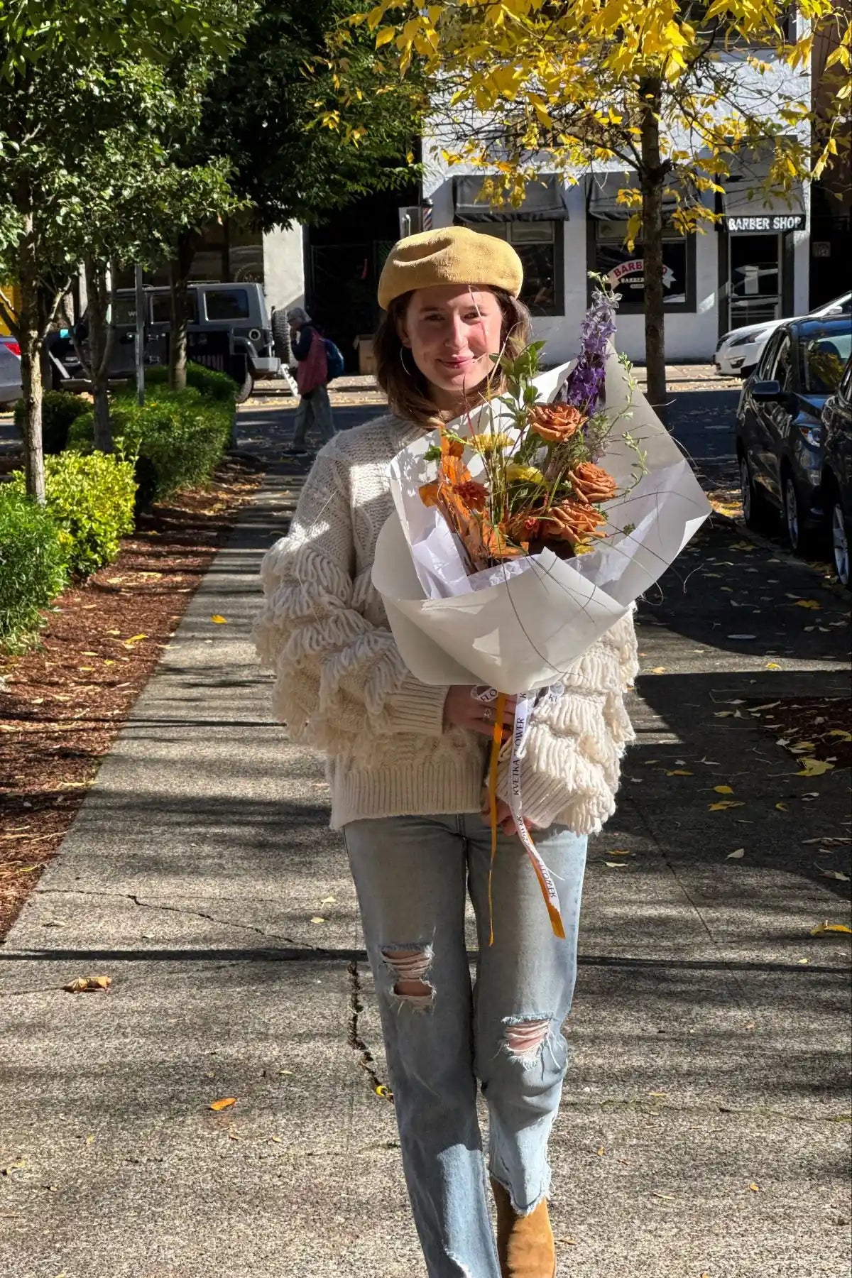 Woman walking with fresh seasonal bouquet small size featuring orange roses and autumn flowers, perfect flower delivery gift