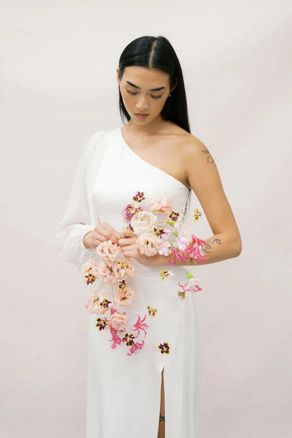 Bride looking down at artistic wire-frame bouquet with lisianthus nerine and orchids by Kvetka Flower Portland
