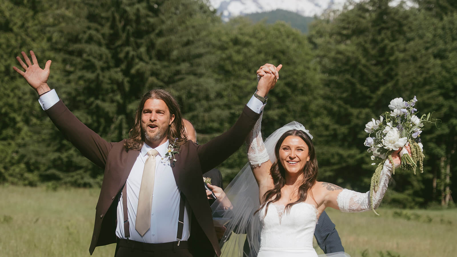Bride and groom celebrating outdoors with floral bouquet created by Kvetka Flower Portland OR