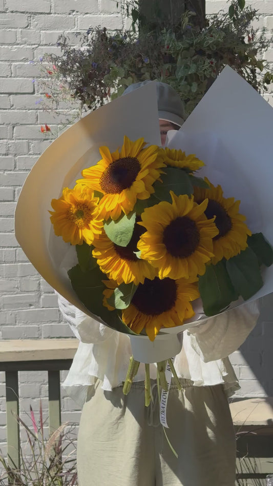 Short video showing small Sun Day sunflower bouquet being turned in hand – wrapped in paper, local flowers from Kvetka Flower Portland OR